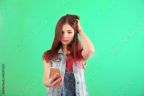 Beautiful young woman with dyed hair on color background