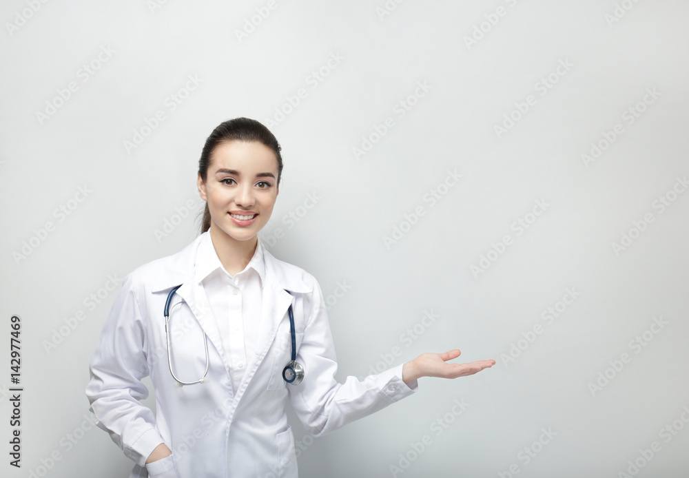 Beautiful young doctor on light background Beautiful young doctor on light background