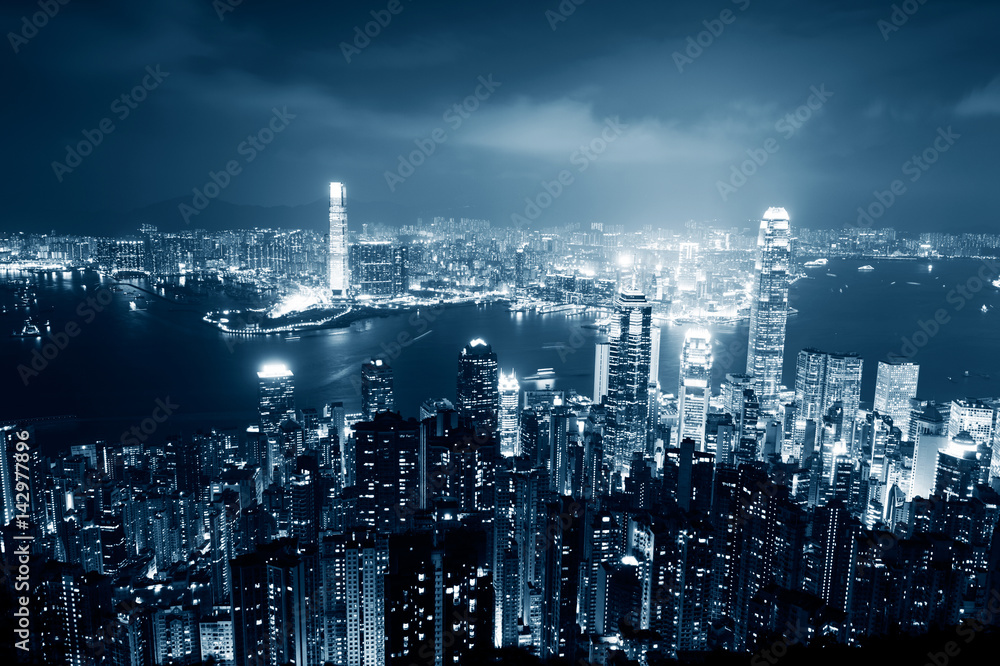 Hong Kong cityscape at night with victoria harbour and large group of tall buildings. Hong Kong cityscape at night with victoria harbour and large group of tall buildings.