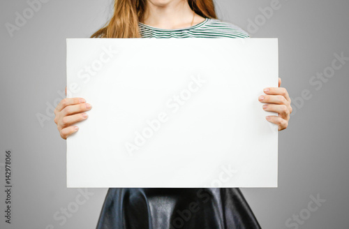 Woman showing blank white big A2 paper. Leaflet presentation. Pamphlet hold hands. Girl show clear offset paper. Sheet template. Booklet design sheet display read first person.