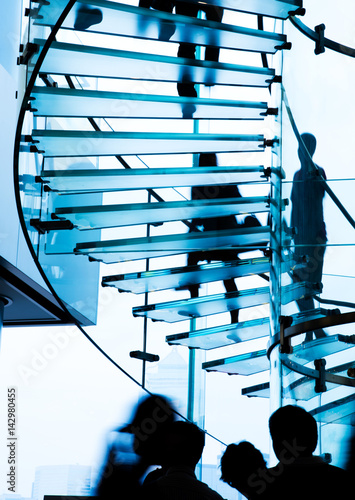 Wall Mural Silhouette people on glass staircase.