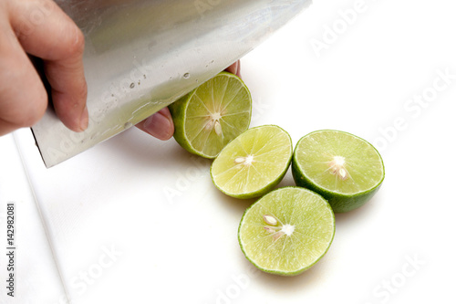 Obraz na płótnie Slicing lime with knife on white cutting board w salonie