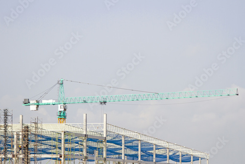 Cranes in green on daylight and working