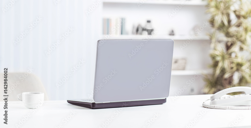 Obraz premium open laptop and Cup of coffee on the table in the nursery.