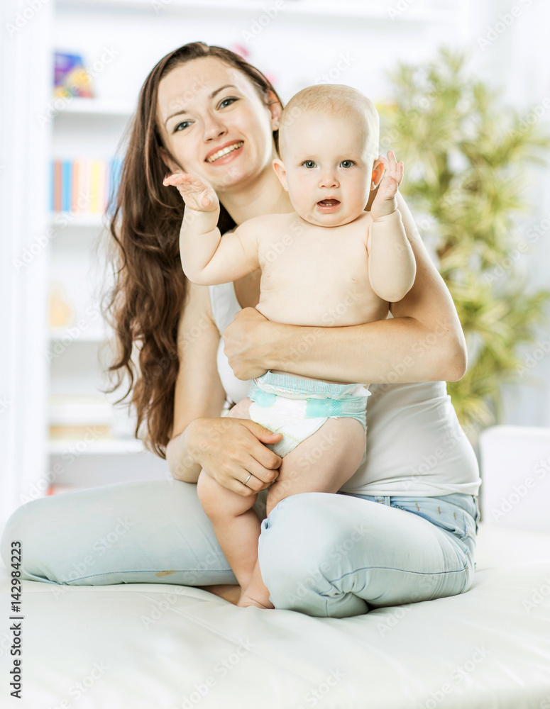 portrait of happy mom with a year old toddler in the background of a child's room portrait of happy mom with a year old toddler in the background of a child's room
