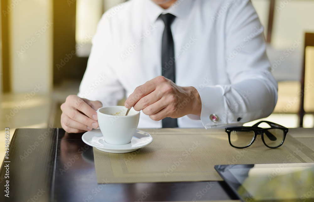 Young businessman sitting in cafe with laptop