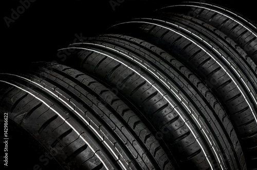 Car tires in row isolated on black