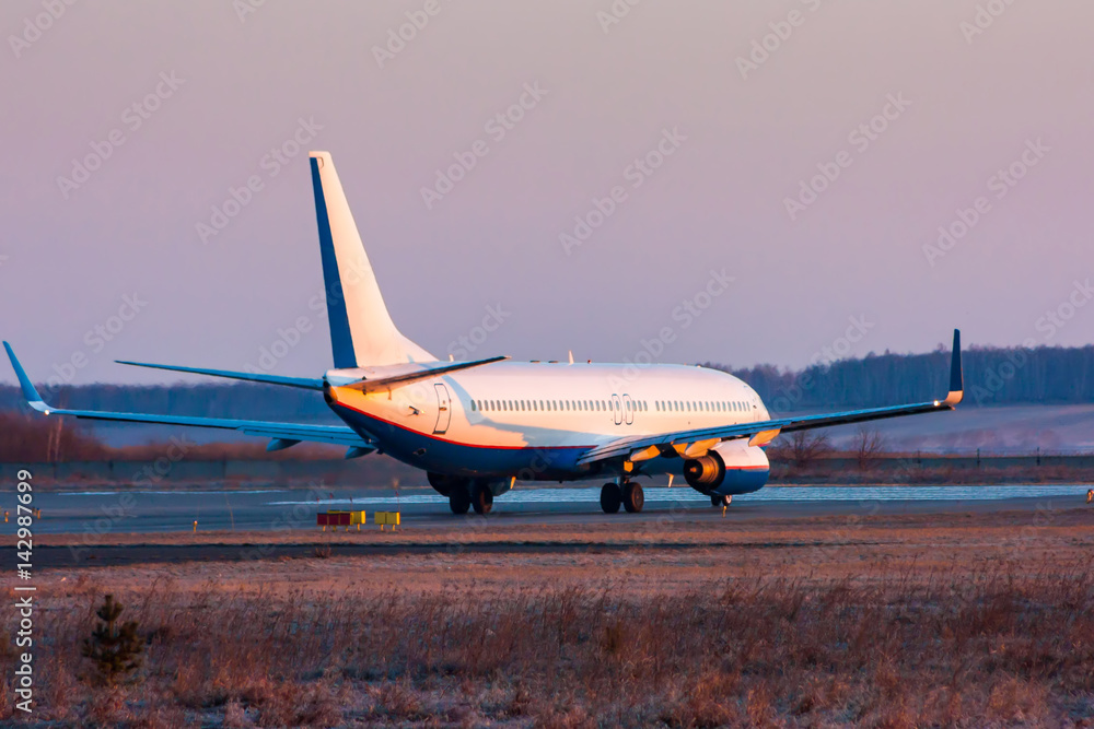 Passenger plane taxiing on the runway in the early morning