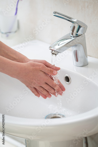 The boy is washing his hands