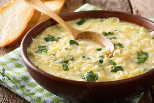 Italian egg cream soup stracciatella with farfalline pasta and cheese close-up. horizontal photo