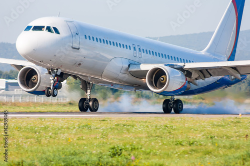 The plane lands. Touching the runway with smoke