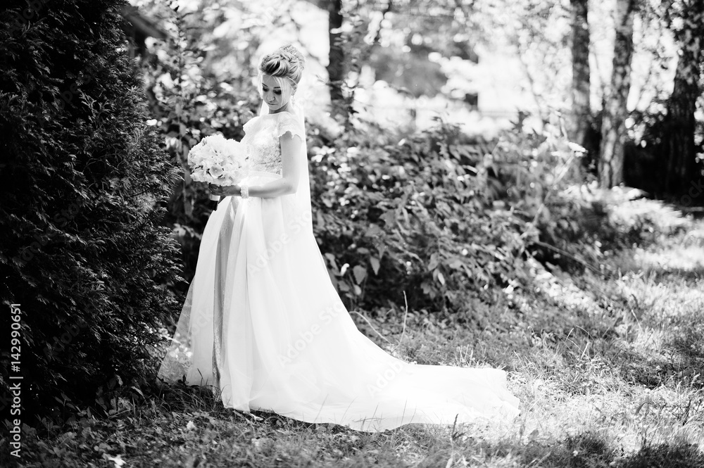 Awesome gorgeous blonde bride with wedding bouquet at hands at sunny day. Awesome gorgeous blonde bride with wedding bouquet at hands at sunny day.