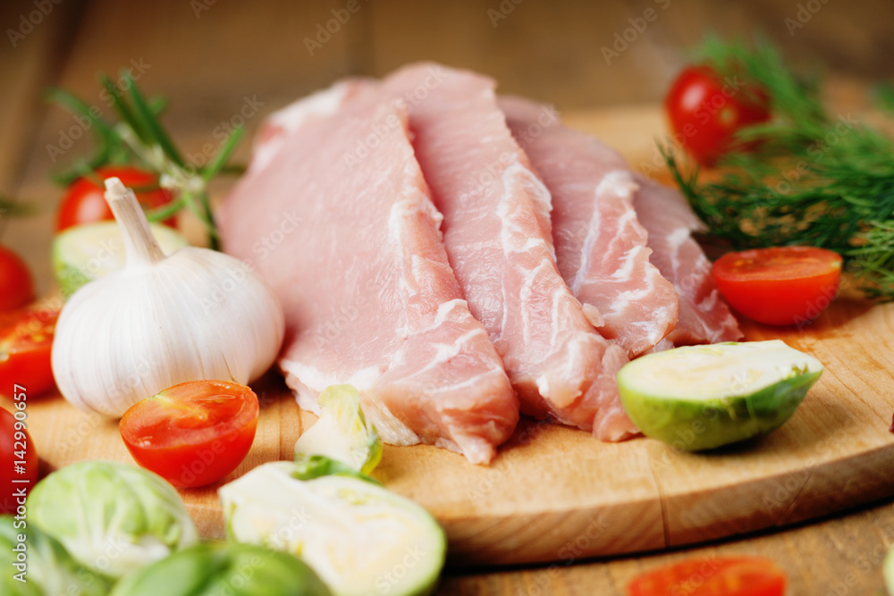 Slices of raw pork meat and vegetables 