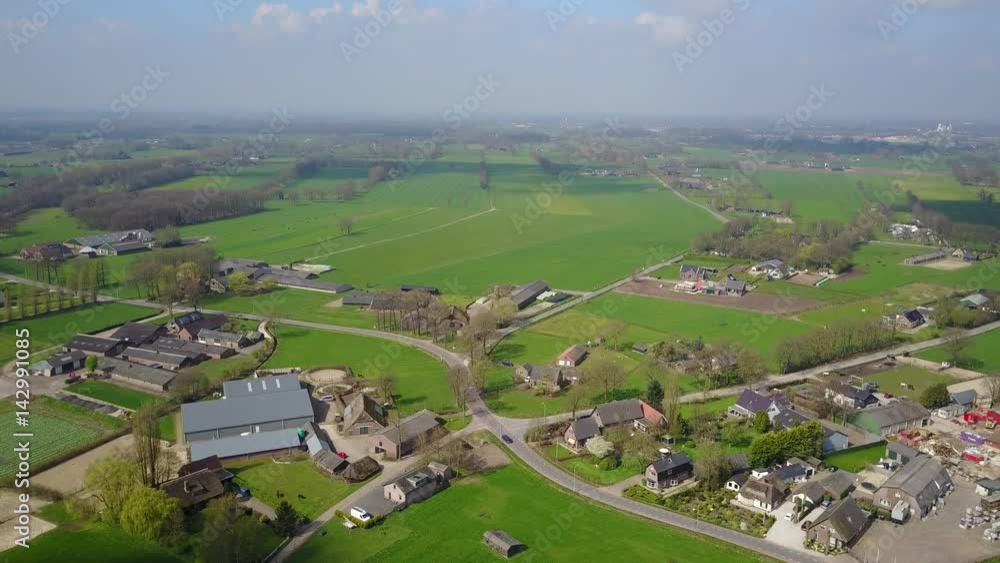 Aerial: Flying over a little Farmland hamlet with green fields and forest around Aerial: Flying over a little Farmland hamlet with green fields and forest around