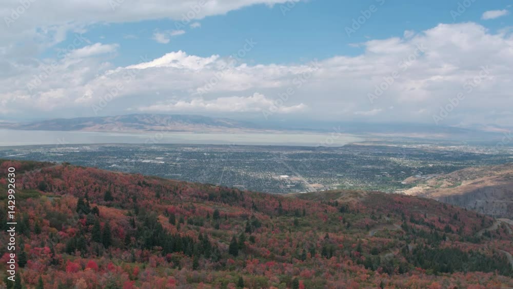Aerial view flying backwards over colorful foliage viewing lake and city Aerial view flying backwards over colorful foliage viewing lake and city
