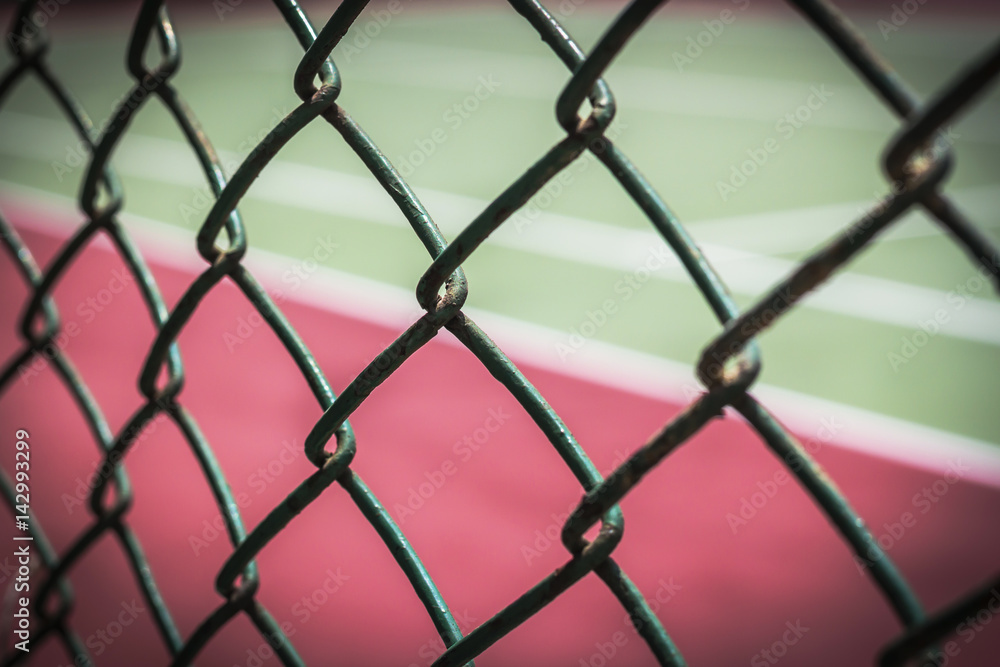 Close-up wire mesh steel with cort tennis background.