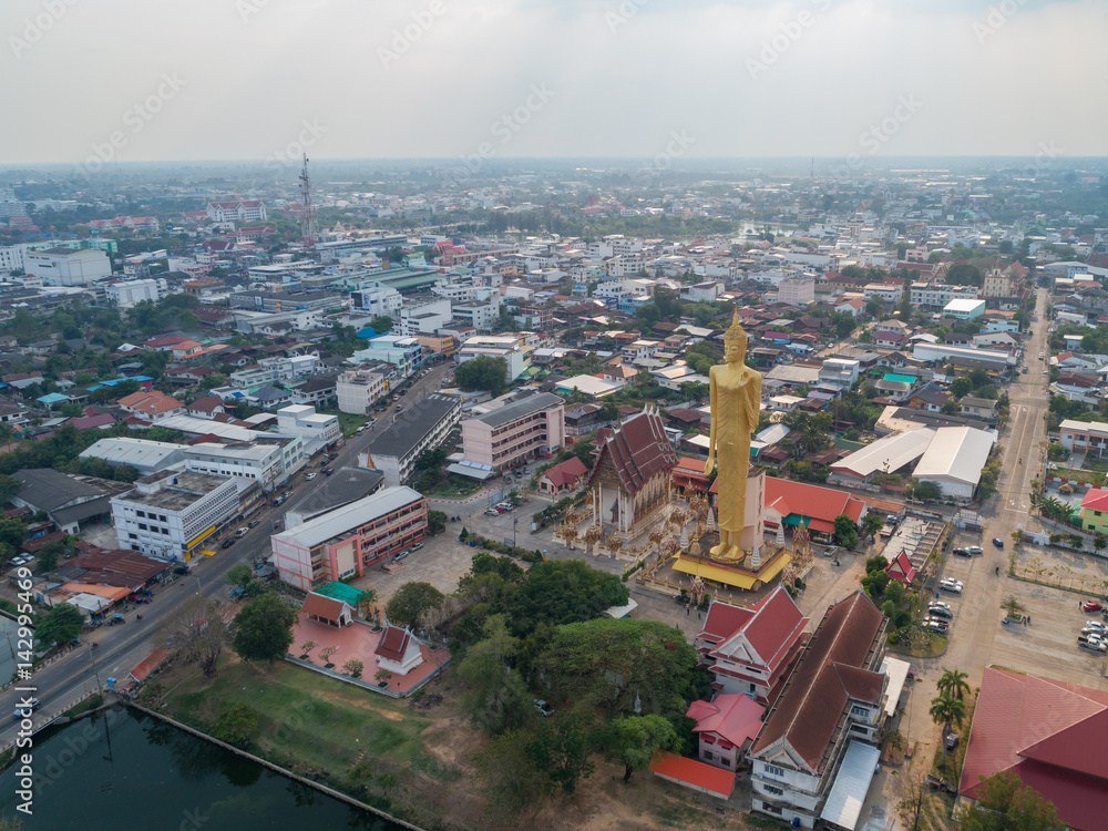 Fototapeta premium Aerial view of TALLEST STANDING BUDDHA IMAGAE IN Roiet, THAILAND - BURAPAPIRAM TEMPLE 