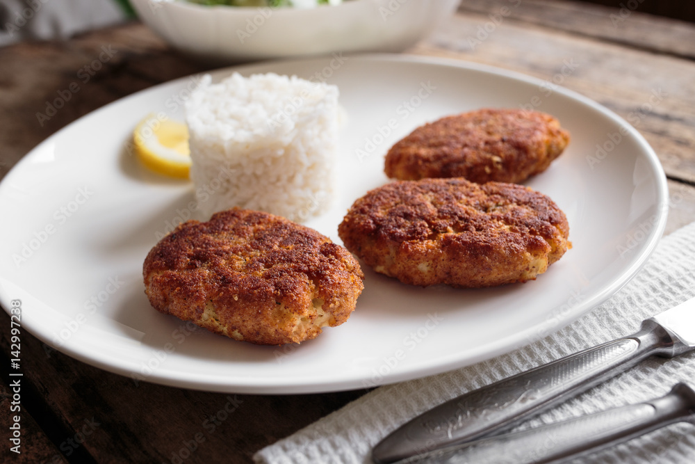 Three fish breadcrumbed cutlet on white plate with rice. Restaurant menu background Three fish breadcrumbed cutlet on white plate with rice. Restaurant menu background