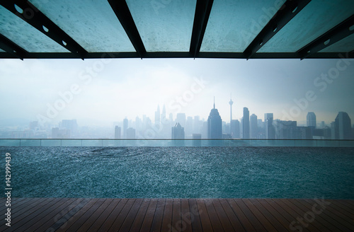 Canvas Print Swimming pool on roof top with beautiful city skylinr view,raining