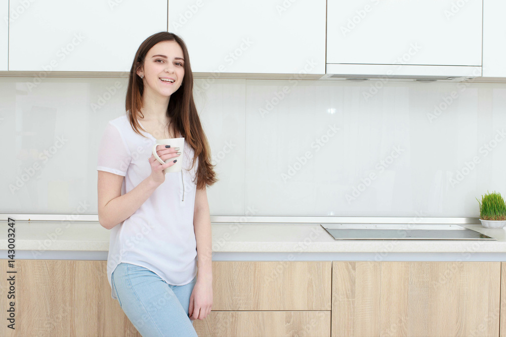 young woman With black hairdrinking coffee in the kitchen young woman With black hairdrinking coffee in the kitchen