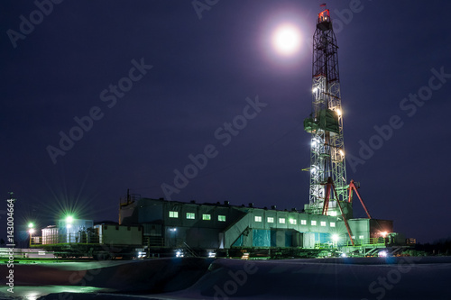 A night view of a derrick drilling in Siberia photo