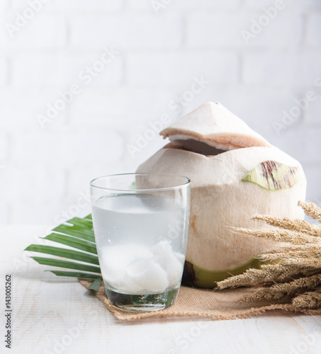 Coconut juice,Drink coconut water on table against white brick wall