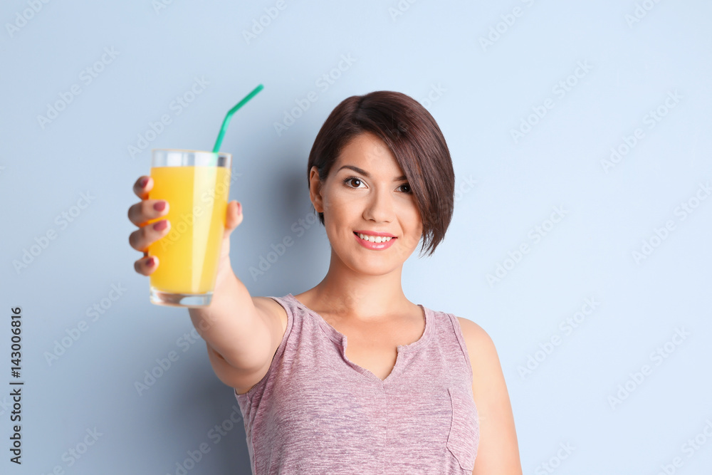 Young beautiful woman with glass of orange juice, on light background Young beautiful woman with glass of orange juice, on light background