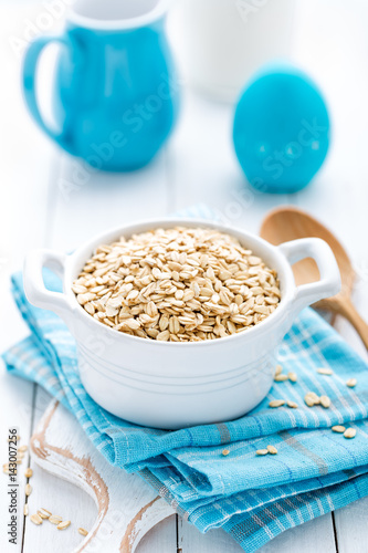 Rolled oats on white wooden background © Sea Wave