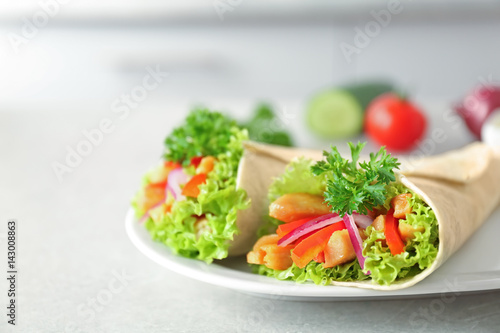 Plate with delicious kebab sandwiches on kitchen table