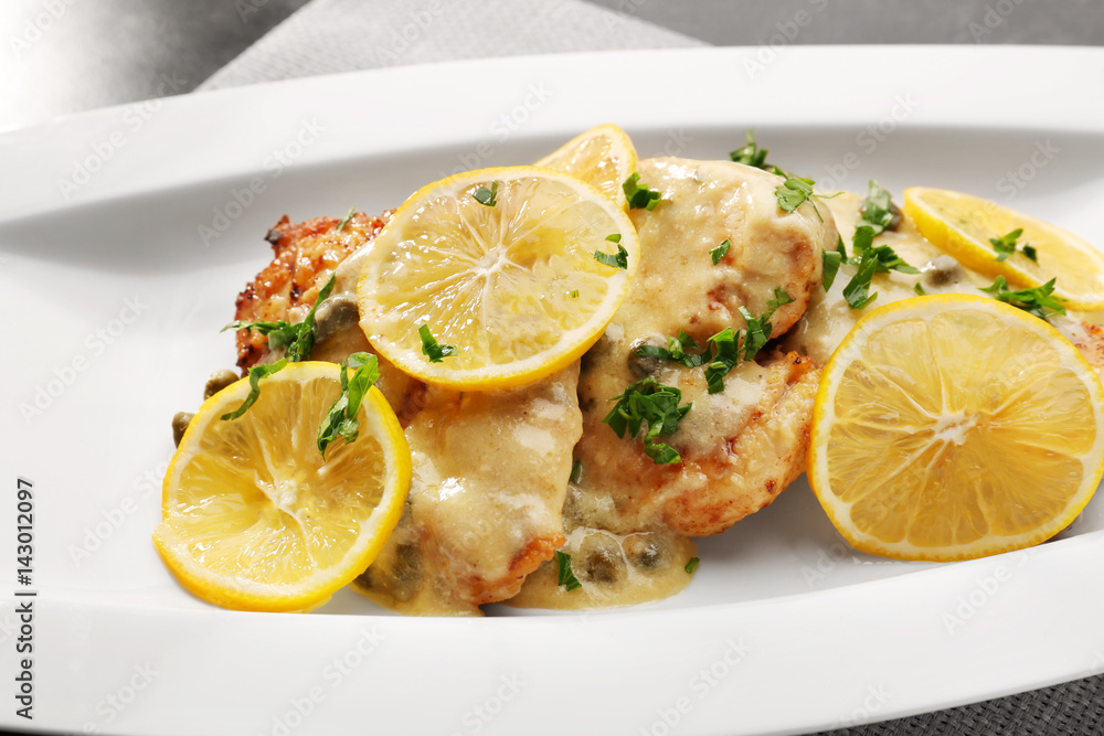 Plate with tasty chicken piccata on table, closeup Plate with tasty chicken piccata on table, closeup