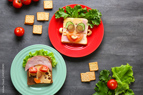 Plates with tasty sandwiches on grey background