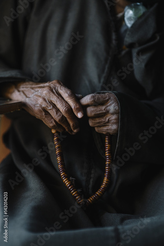 Midsection of man holding beads talisman