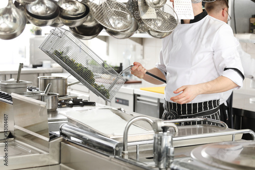 Obraz na płótnie Chef in hotel or restaurant kitchen cooking
w salonie