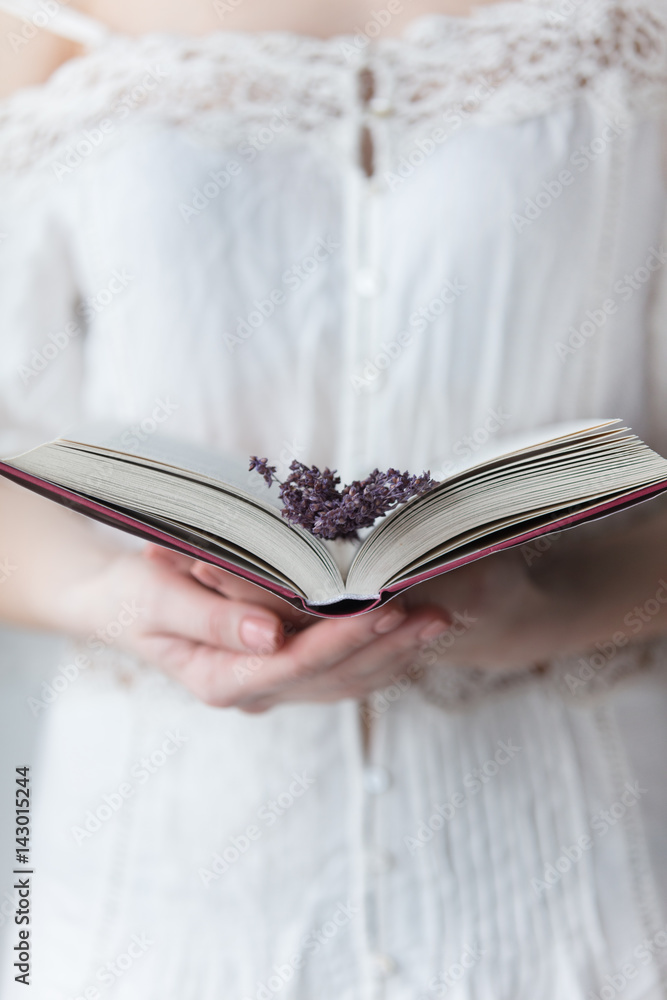 Φωτογραφία photo of young woman holding opened book with branch of lavender on the wonderfu