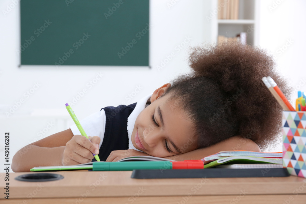 Φωτογραφία Tired african american schoolgirl sleeping on desk during class, education and c