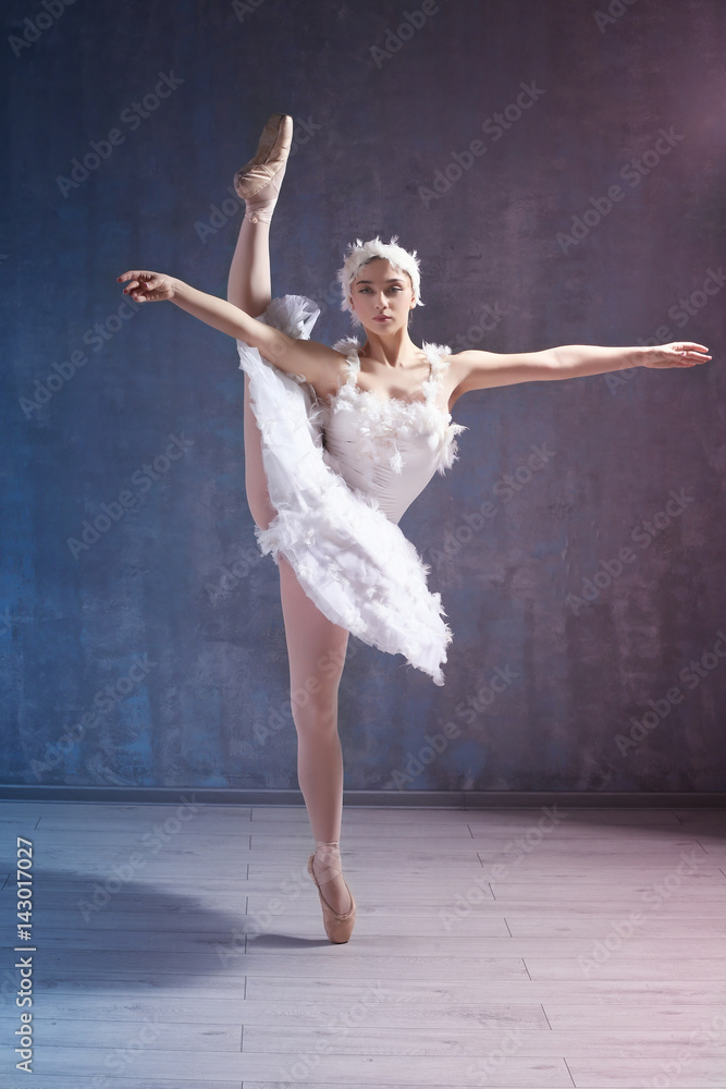 Fototapeta premium Young beautiful ballerina dancing in studio