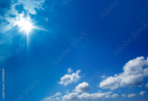 cloudscape image of clear blue sky with shining sun.