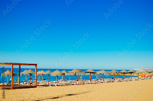 Blue sky and beach umbrella chair on beautiful tropical ocean coastline  sunny outdoors scenic background