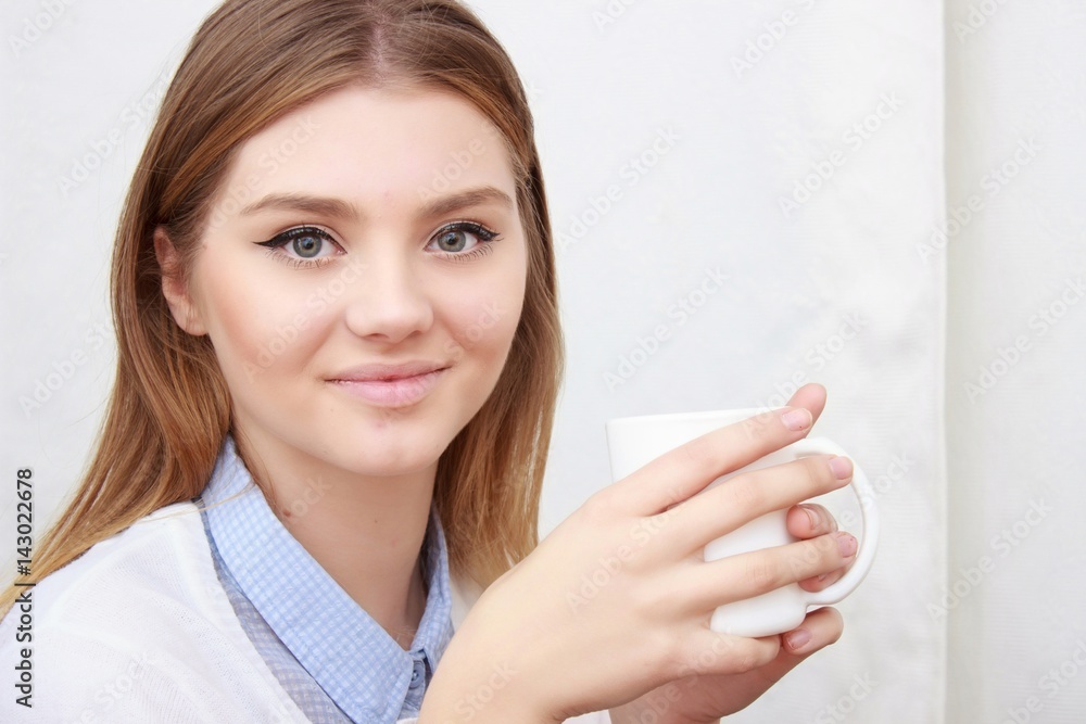 woman sitting on couch in her living room and drinking coffee woman sitting on couch in her living room and drinking coffee