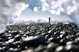 Diamond Beach (Ice Beach) in iceland - woman standing between block of ice and taking a photo