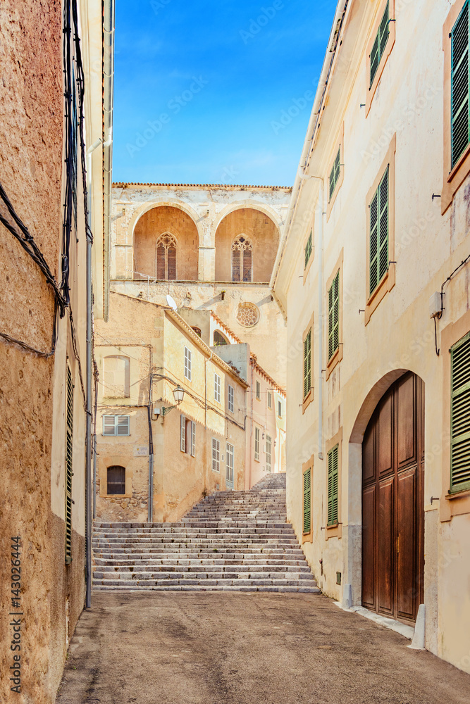 The narrow old street in the historic center of Arta, Mallorca, Spain. Beautiful sunny day for traveling and feel the atmosphere of the historic town.