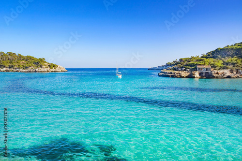 Beautiful and calm beach S'Amarador in Mallorca with a boat in the center. This amazing beach is located in the south of Majorca.