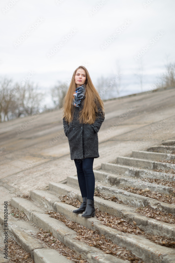 Portrait of a beautiful girl in early spring on the steps Portrait of a beautiful girl in early spring on the steps