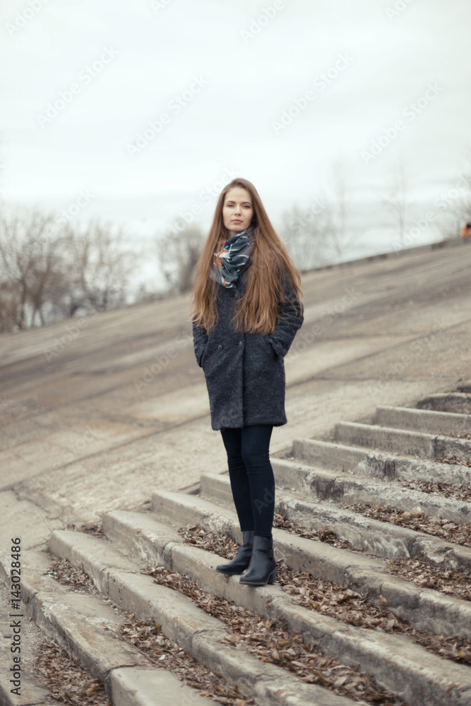 Portrait of a beautiful girl in early spring on the steps Portrait of a beautiful girl in early spring on the steps