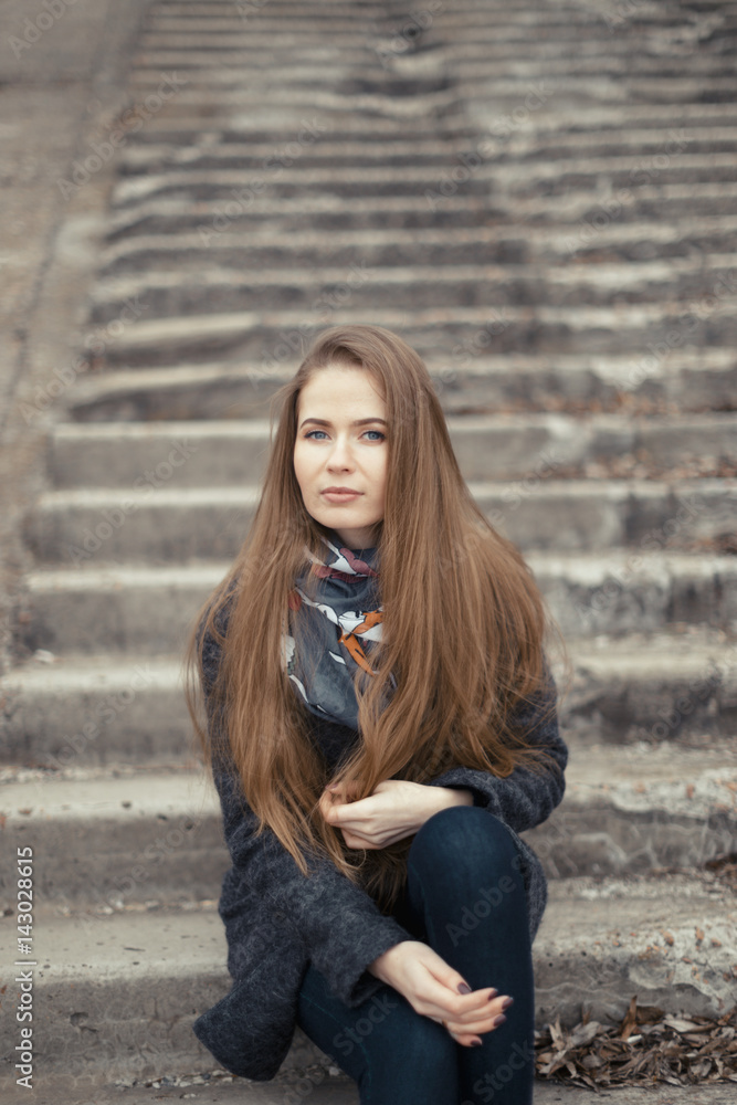 Portrait of a beautiful girl in early spring on the steps Portrait of a beautiful girl in early spring on the steps