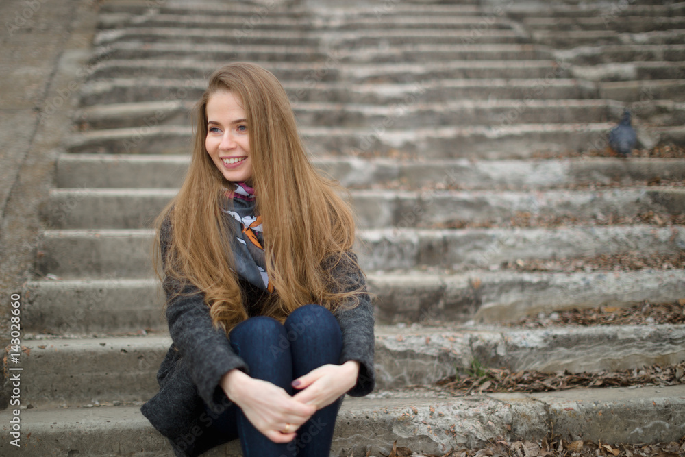 Portrait of a beautiful girl in early spring on the steps Portrait of a beautiful girl in early spring on the steps