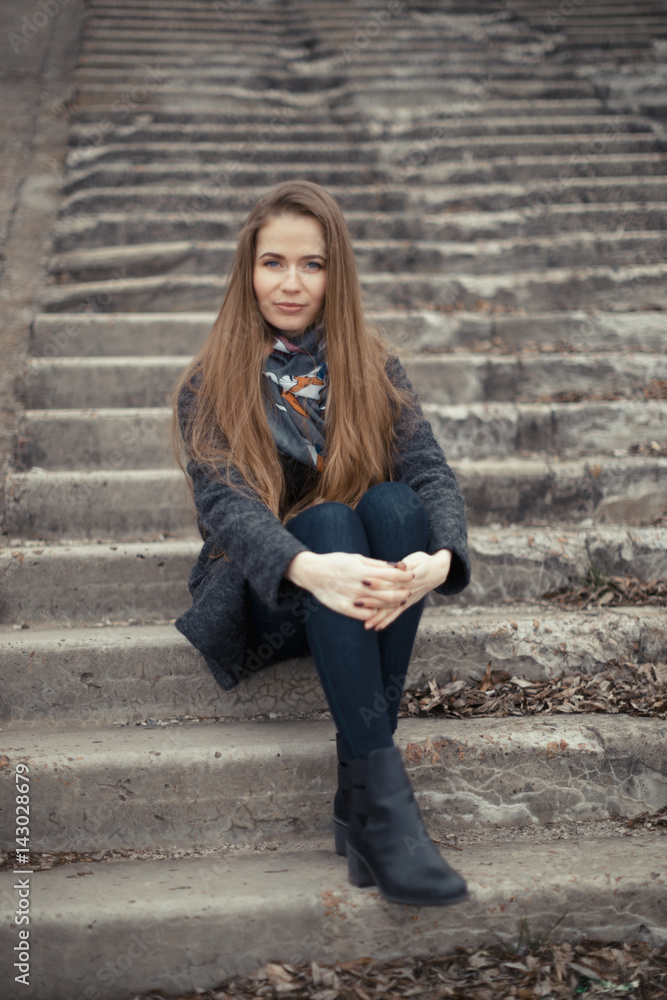 Portrait of a beautiful girl in early spring on the steps Portrait of a beautiful girl in early spring on the steps