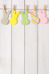 Garland with easter bunnies on white wood background, copy space