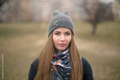 Portrait of a beautiful girl in early spring in a gray cap