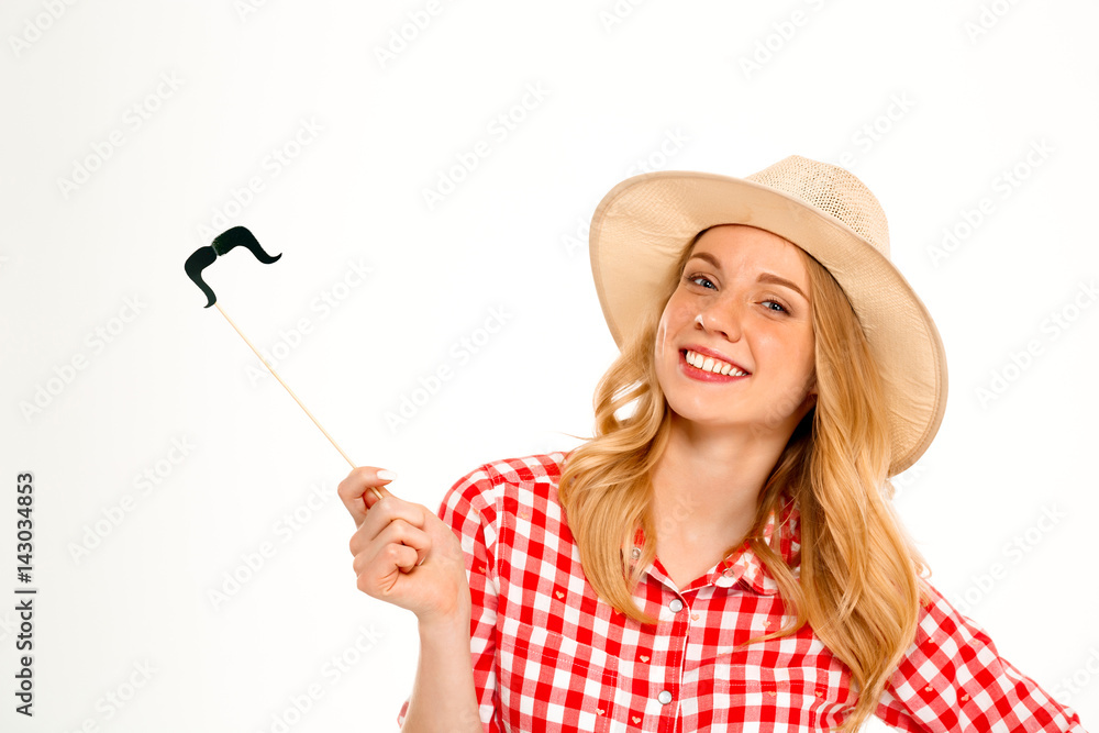 Portrait of country girl wearing fake mustache over white background. Portrait of country girl wearing fake mustache over white background.